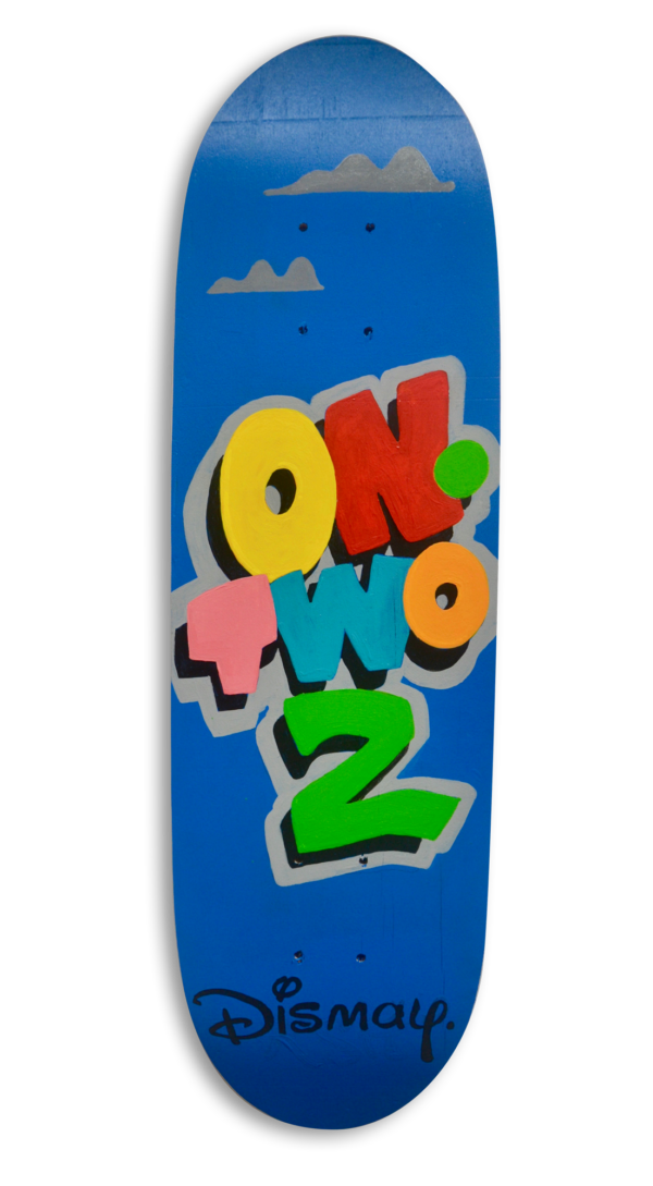 A skateboard with a blue sky background and the text in colourful letters "On Two 2" and the logo "Dismay" resembling the Disney logo.