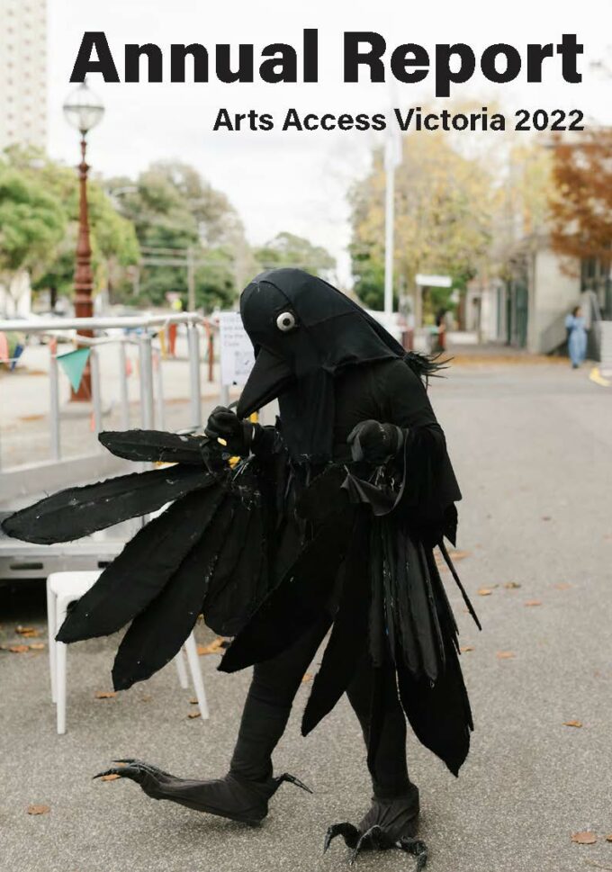 Arts Access Victoria Annual Report Cover, a person in a crow costume walks on concrete.