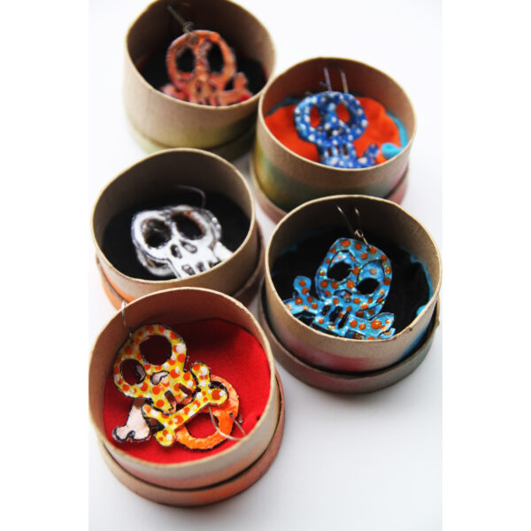 Dangaling Skull earrings in round boxes.