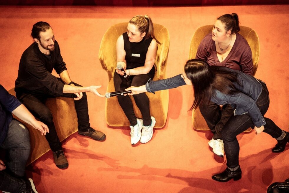 A group of people are sitting in chairs talking