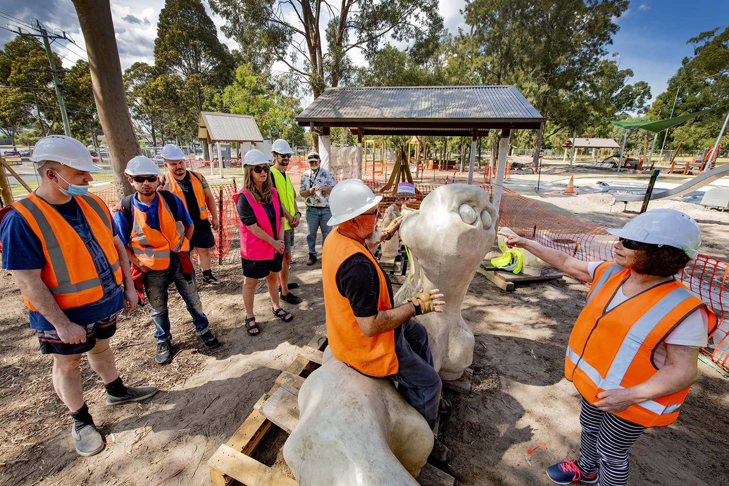 Artists with project manager and sculptures