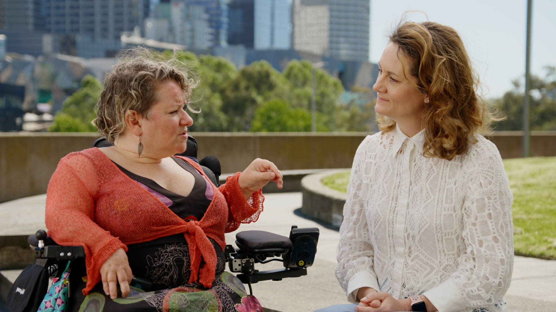 Caroline Bowditch and Claire Spencer in conversation outside on a sunny day.