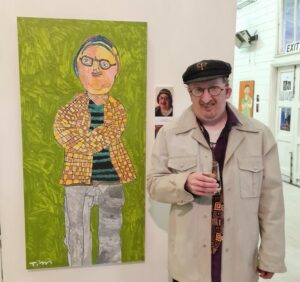 Tim Sedgwick is standing next to one of his painting in a gallery