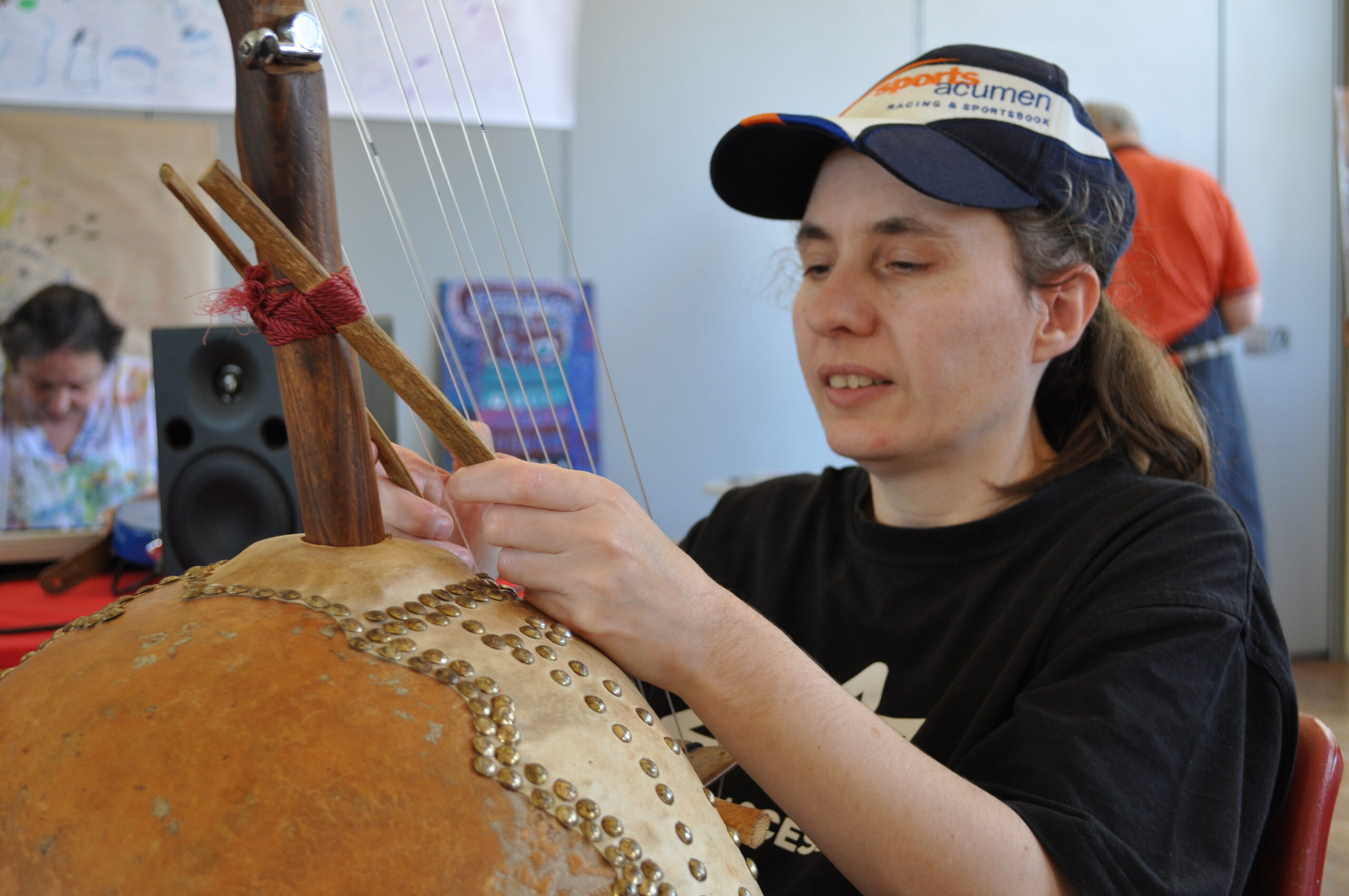 Paula seated holding a large string instrument.