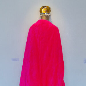 mannequin's back wearing a pink cape and a royal crown made of a mix of paper and materials.