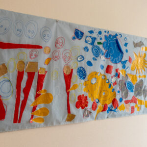 yellow suns, blue, red and grey fabric shapes appliqued onto a white banner.