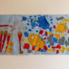 yellow suns, blue, red and grey fabric shapes appliqued onto a white banner.