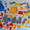 yellow suns, blue, red and grey fabric shapes appliqued onto a white banner.