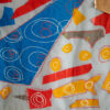 red, yellow and blue fabric geometric shapes appliqued onto a white background.