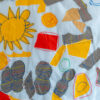 yellow sun, grey clouds, and red, blue and yellow shapes appliqued onto a white background.