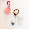 colourful knotted material loops threaded with wool and hanging on a white wall