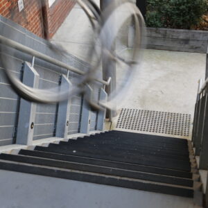 A view down a set of stairs with two steel circles seen on the top right, blurred.
