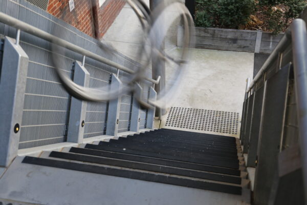 A view down a set of stairs with two steel circles seen on the top right, blurred.