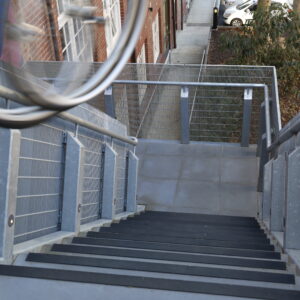 Two wheels are seen in motion rolling down a set of stairs.