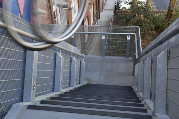 Two wheels are seen in motion rolling down a set of stairs.