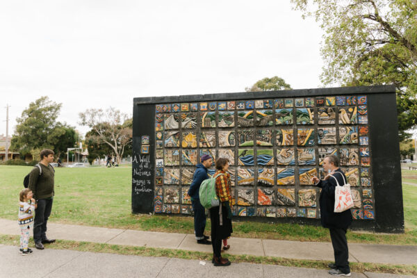 people talking in front of a mural
