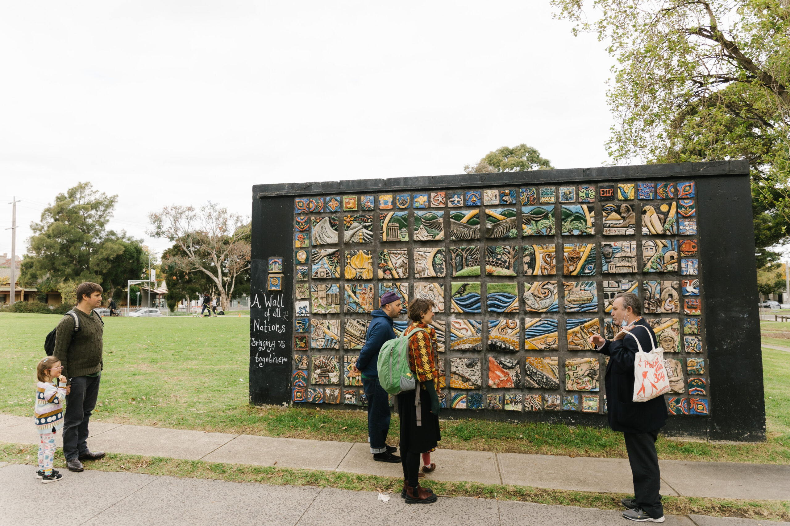 people talking in front of a mural