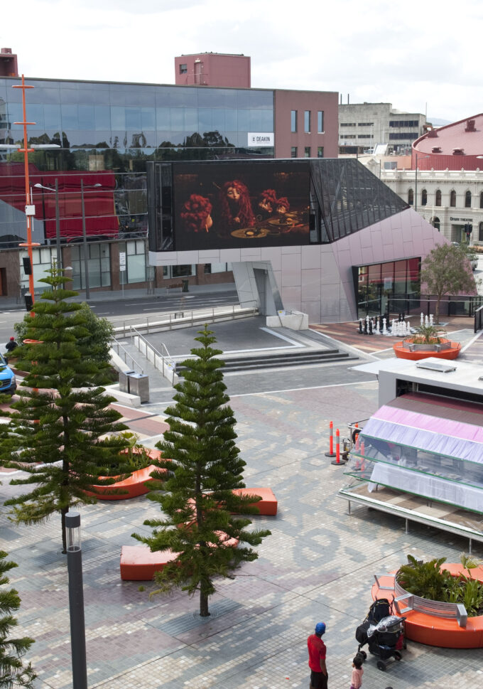 Nebula art space in a city square with tall fir trees to the side