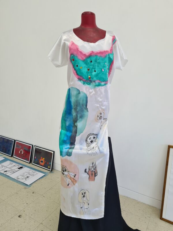 A white satin dress covered in paintings of famous women.