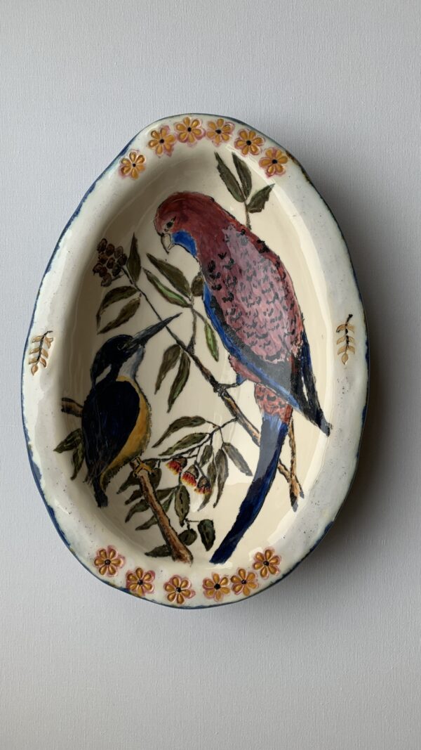 An egg shaped ceramic bowl featuring different species of birds.