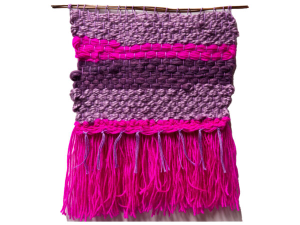 A weaving done with wool. It has pink, purple and mauve stripes with bright pink tassels.