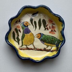 A ceramic bowl with three finches on a gum tree branch.