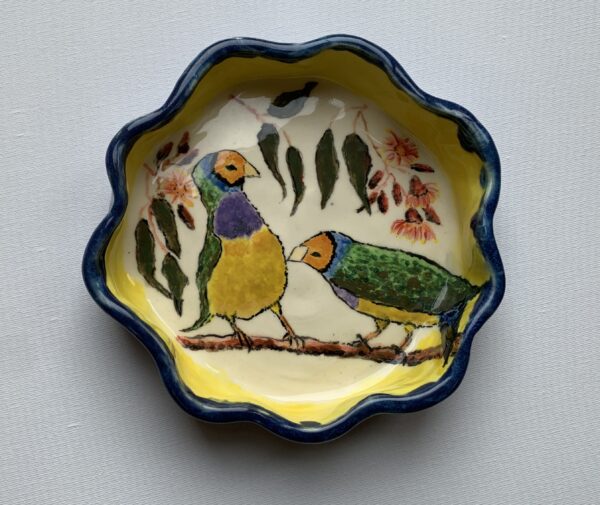 A ceramic bowl with three finches on a gum tree branch.