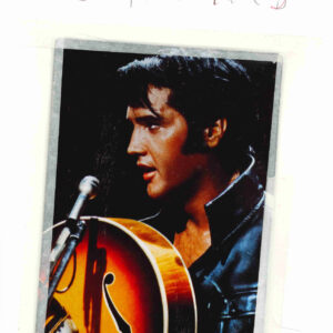 A photograph of Elvis holding a guitar attached to a piece of paper using making tape. With the name Elvis. G. Thomas written on top using red pencil colours.