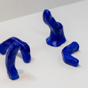 A ceramic sculpture comprised of four bent fingers and a thumb.