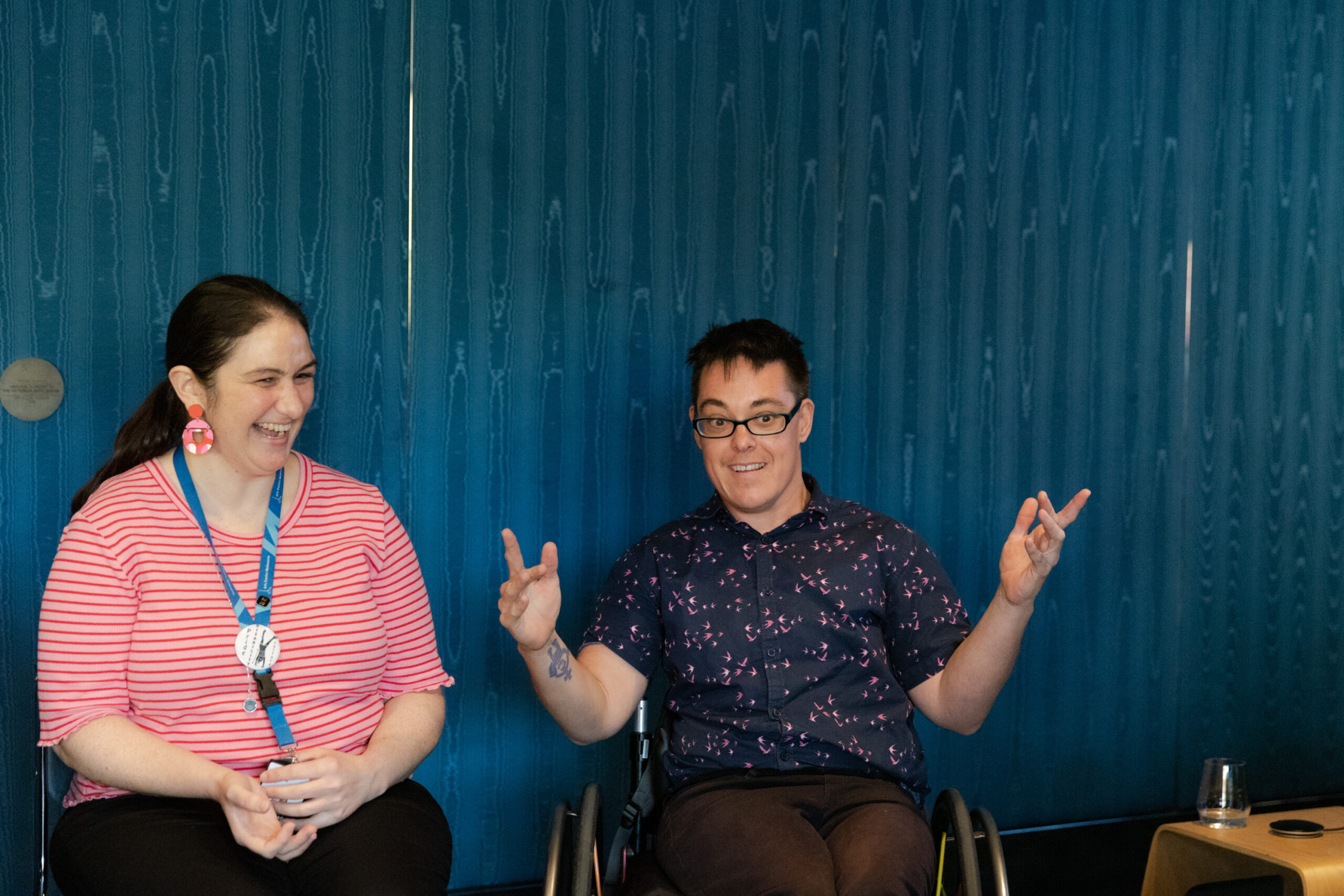 two people are sitting chairs talking