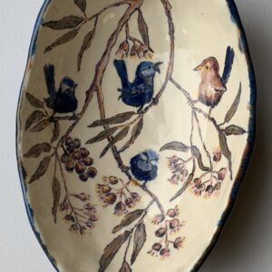 An egg shaped ceramic bowl with fairywrens perched in a gum tree.