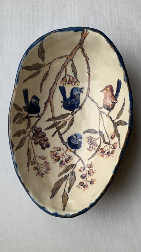 An egg shaped ceramic bowl with fairywrens perched in a gum tree.