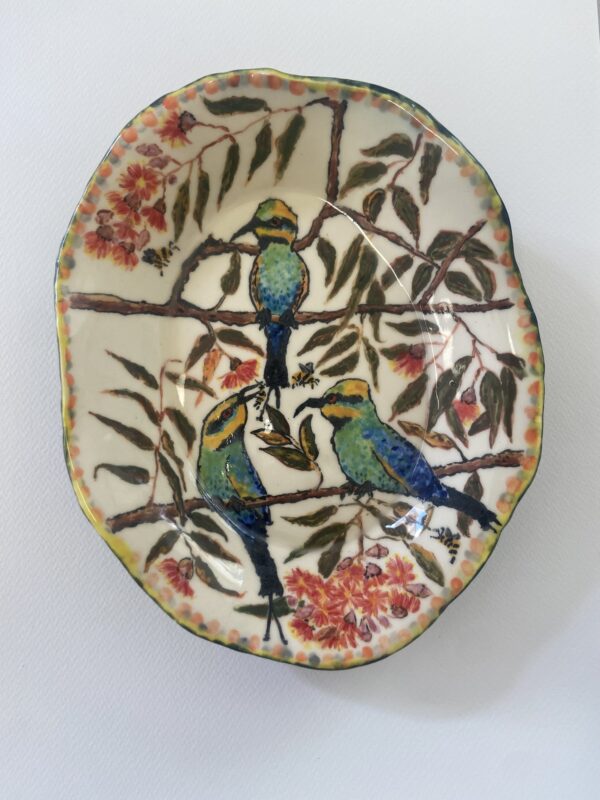 A ceramic bowl showing three rainbow bee-eater birds on a gum tree.