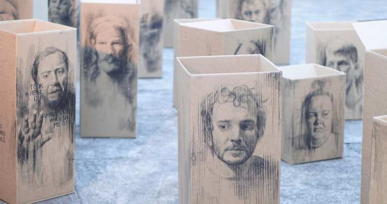 peoples faces are drawn onto cardboard boxes.