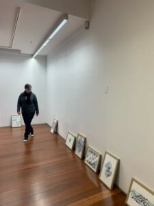 Aleshanee walking through the gallery space at the Dax Centre preparing to install their 'Blue on Blue on Blue' works.