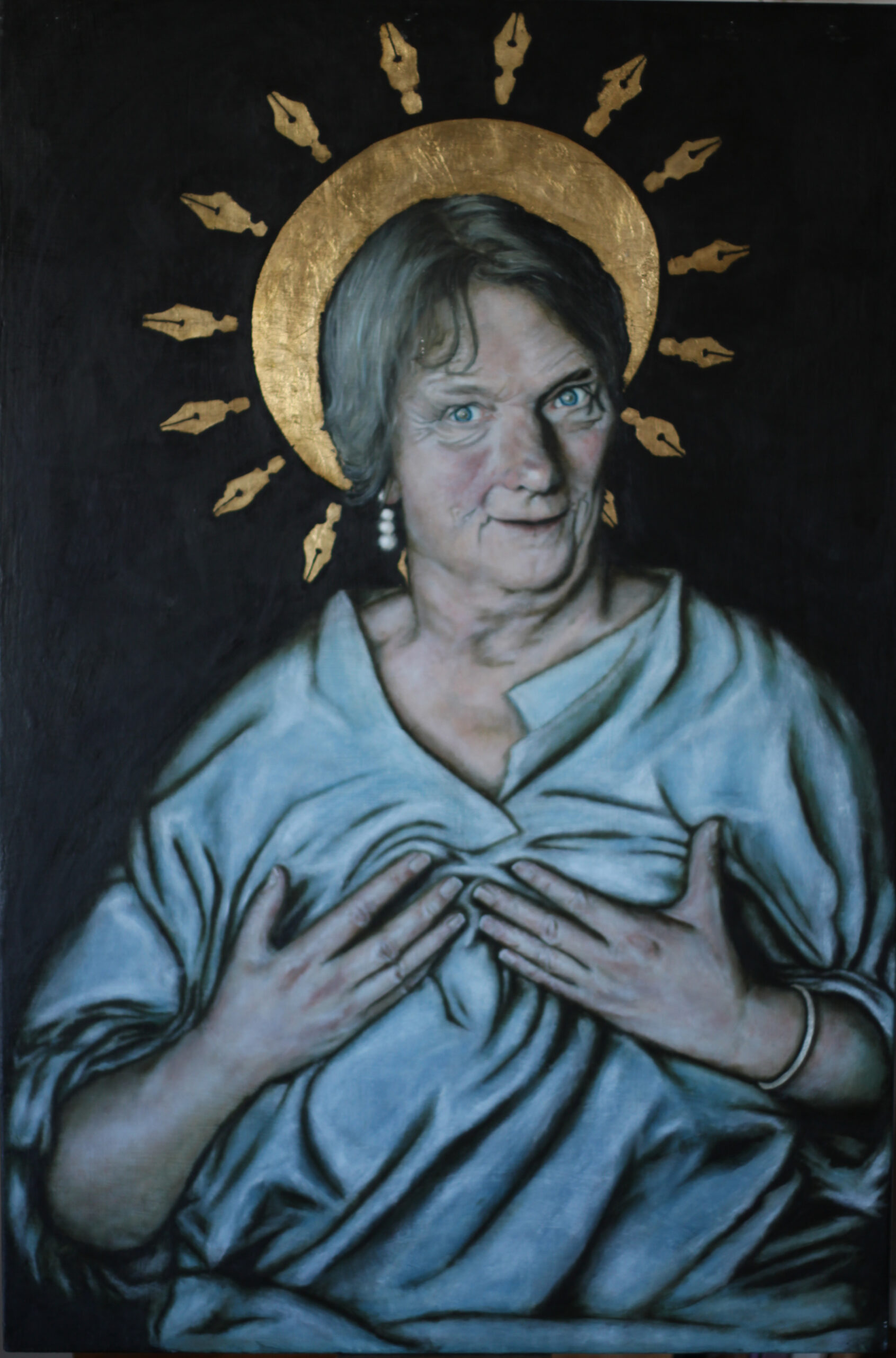 A painted portrait of a seated 75 year old anglo British woman from the waist up. She is pressing on her breasts, with the blue folds of clothing bunched up around her hands. She stares at the viewer with her head slightly tilted and turned. There is a gold halo over her head with spikes of large gold pen nibs surrounding her head. The painting has a plain dark background.