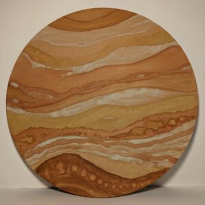 An ochre painting on a round wooden board featuring repetitive curved lines and circular patterns in earthy tones giving the impression of a landscape.