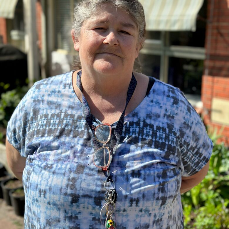 Leeann outside her house, sunlight on her face