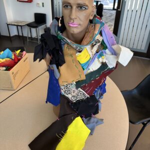 A series of fabrics connected together and wrapped round a mannequins head.