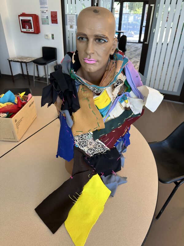 A series of fabrics connected together and wrapped round a mannequins head.