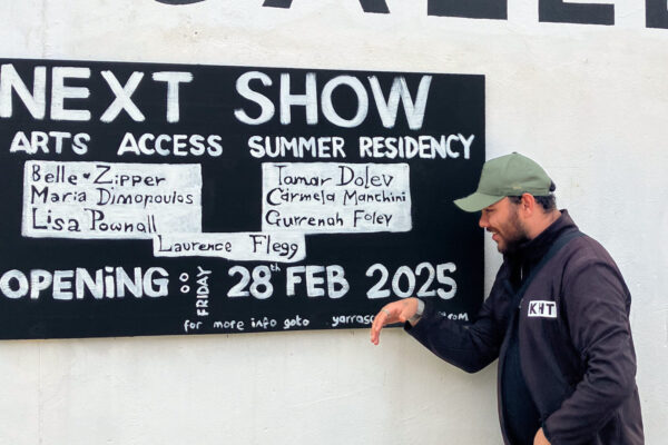 Gurrenah Foley pointing at the exhibition signs