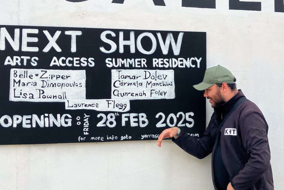 Gurrenah Foley pointing at the exhibition signs
