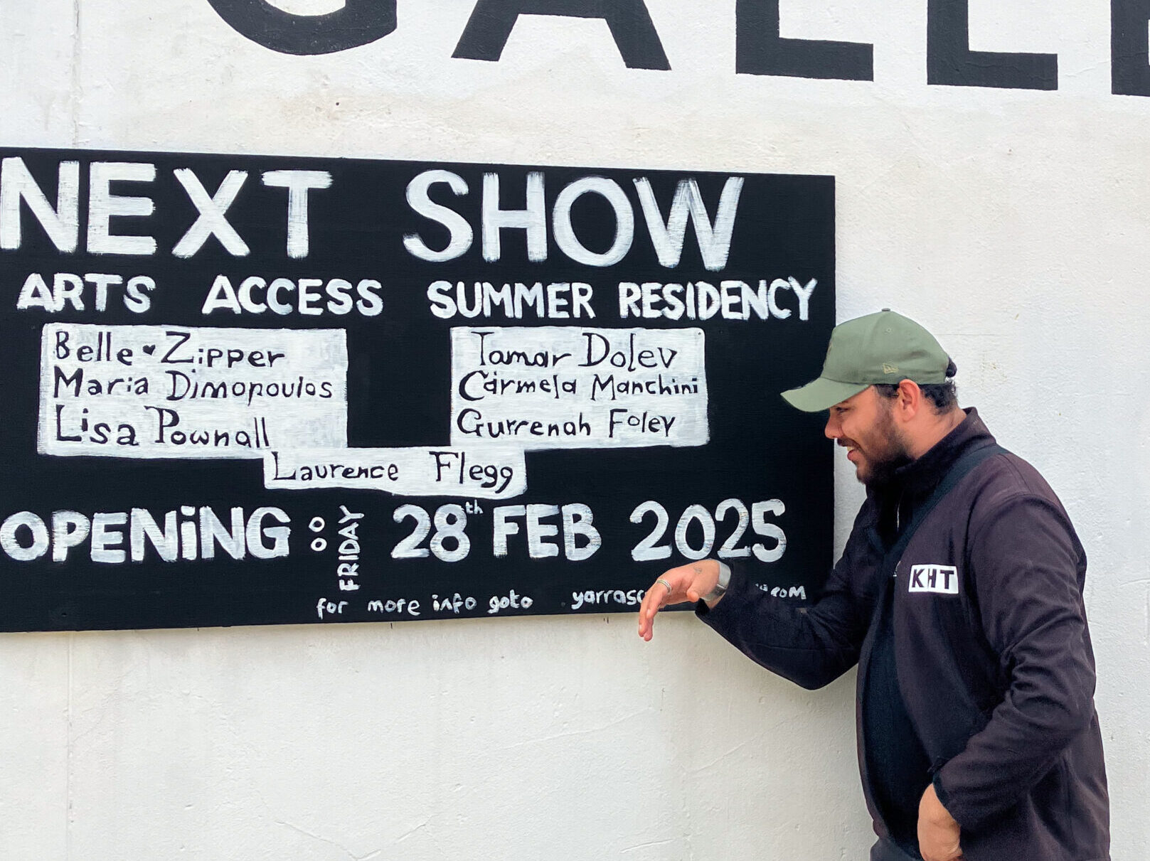 Gurrenah Foley pointing at the exhibition signs