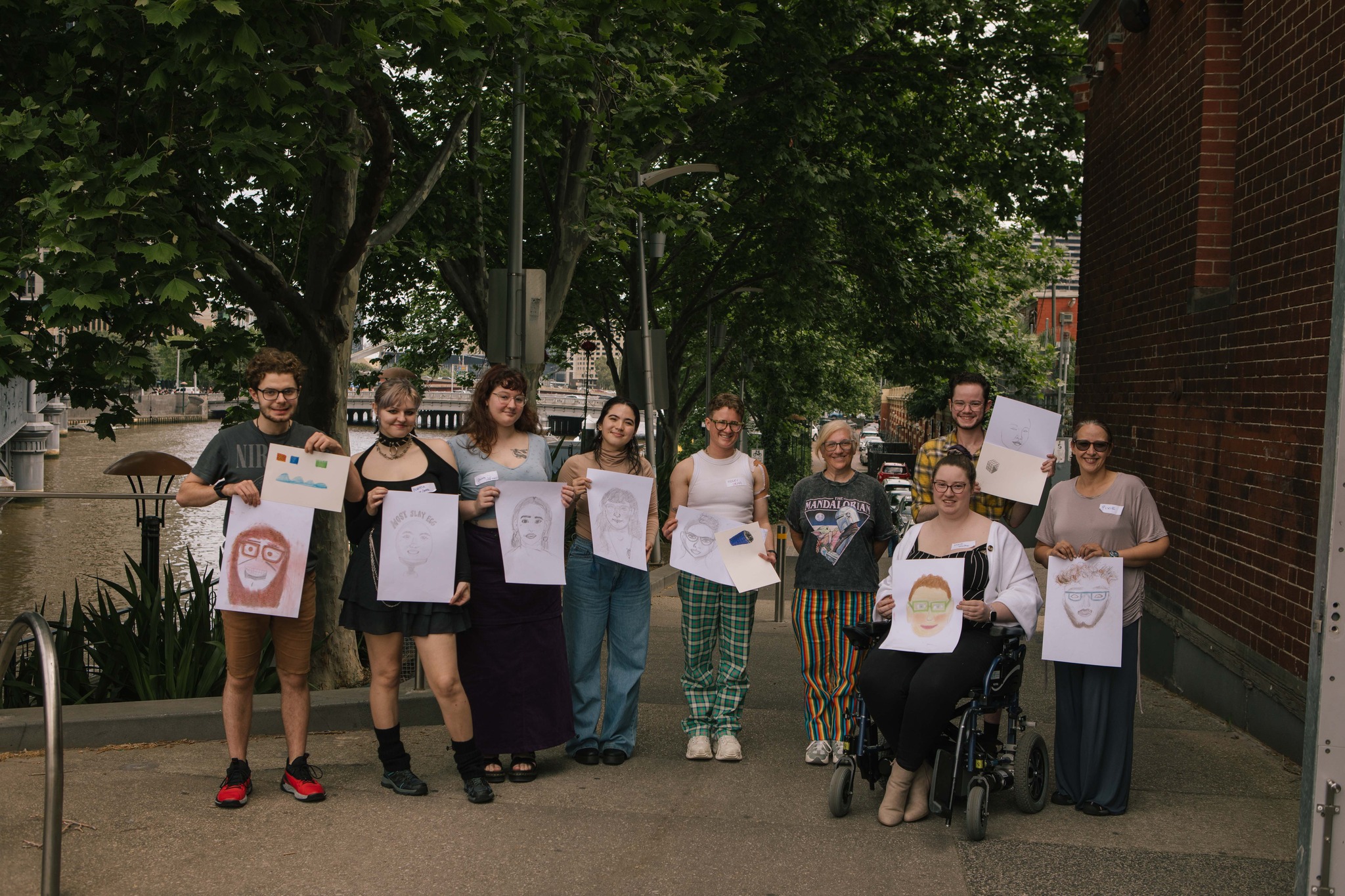 Image Description: a group of young disabled artists proudly showing their work.