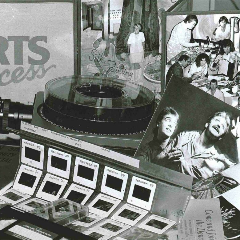 A selection of Arts Access 1980s archive materials displayed on a table in a black and white photograph.