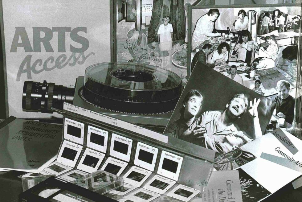 A selection of Arts Access 1980s archive materials displayed on a table in a black and white photograph.