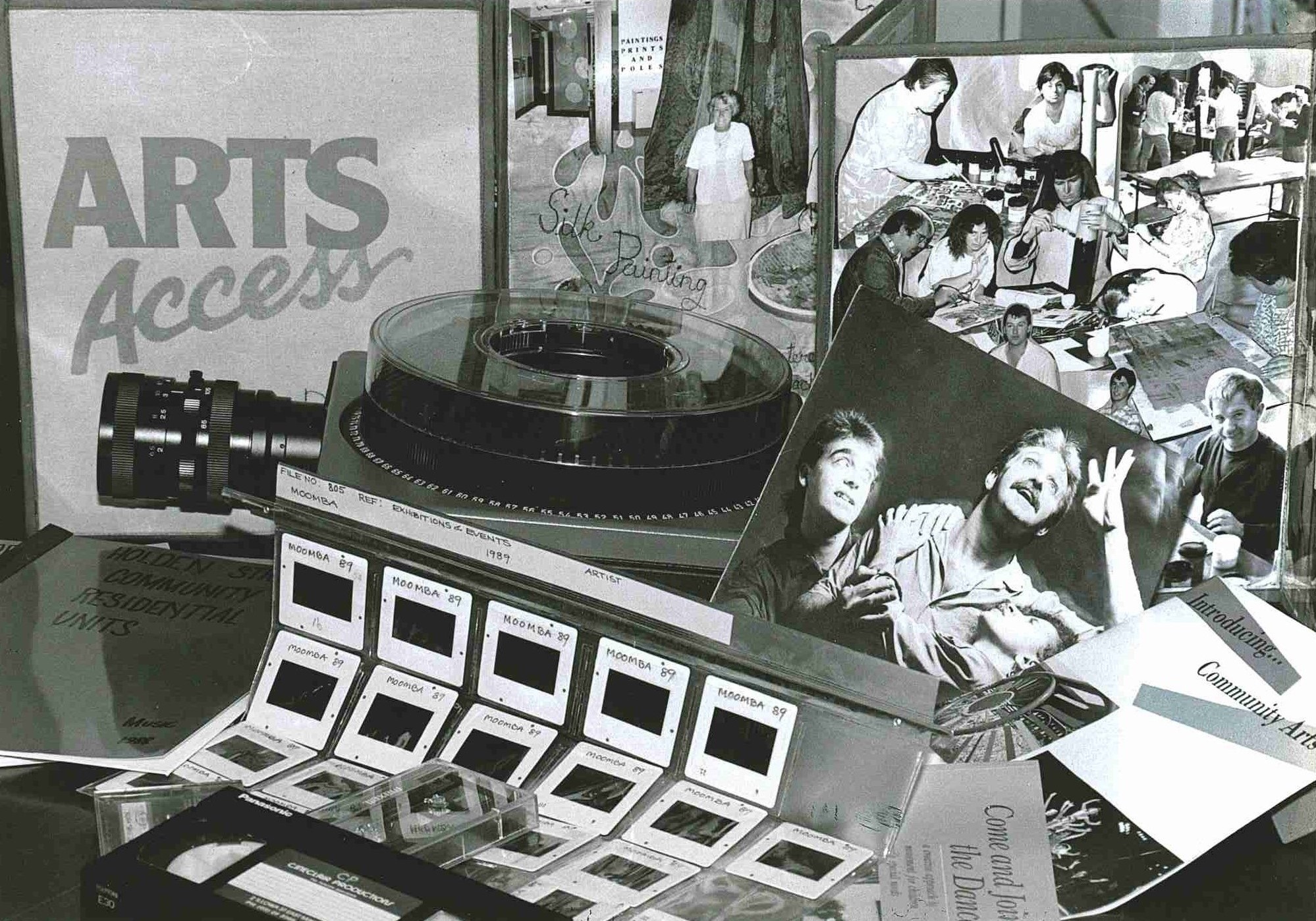 A selection of Arts Access 1980s archive materials displayed on a table in a black and white photograph.