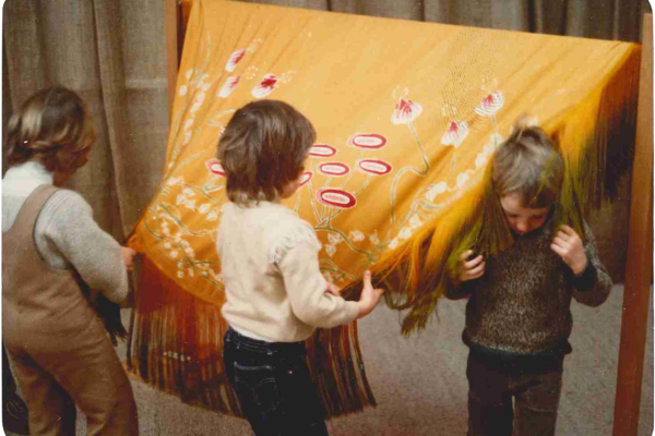 Kids playing with orange fabric.
