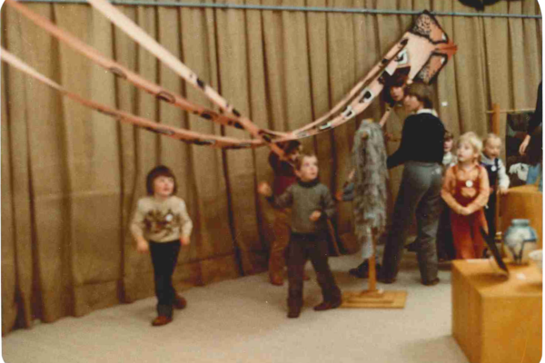 Kids playing with hanging fabric.