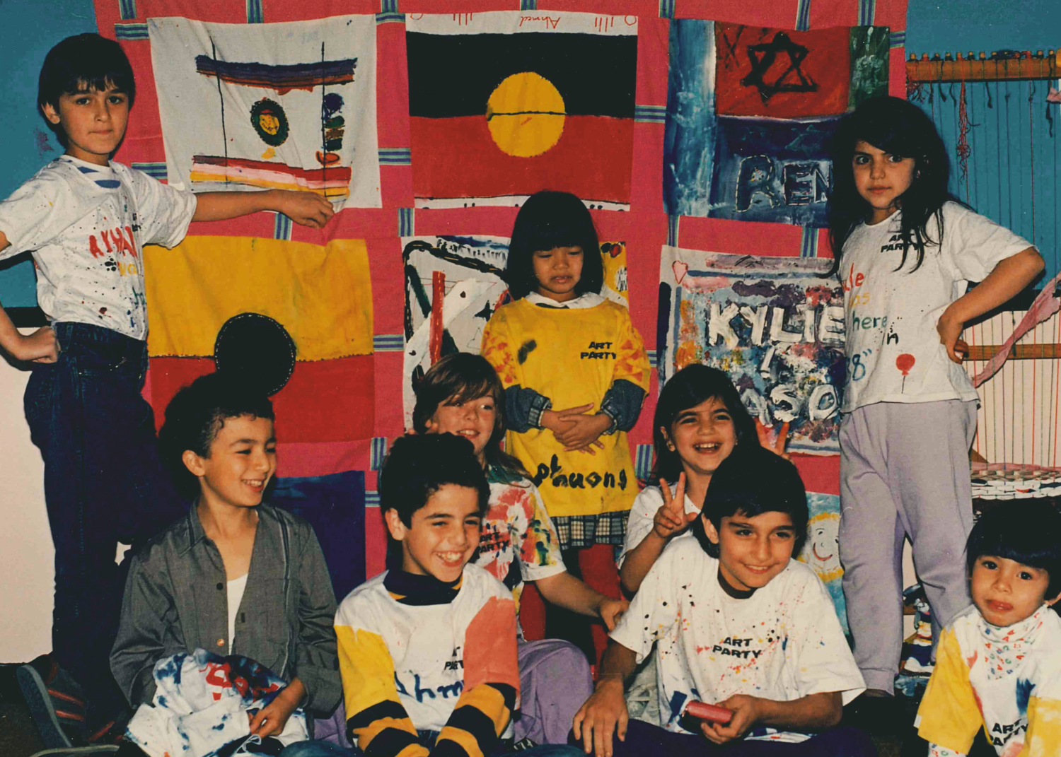 a group of children standing in front of flags they made.